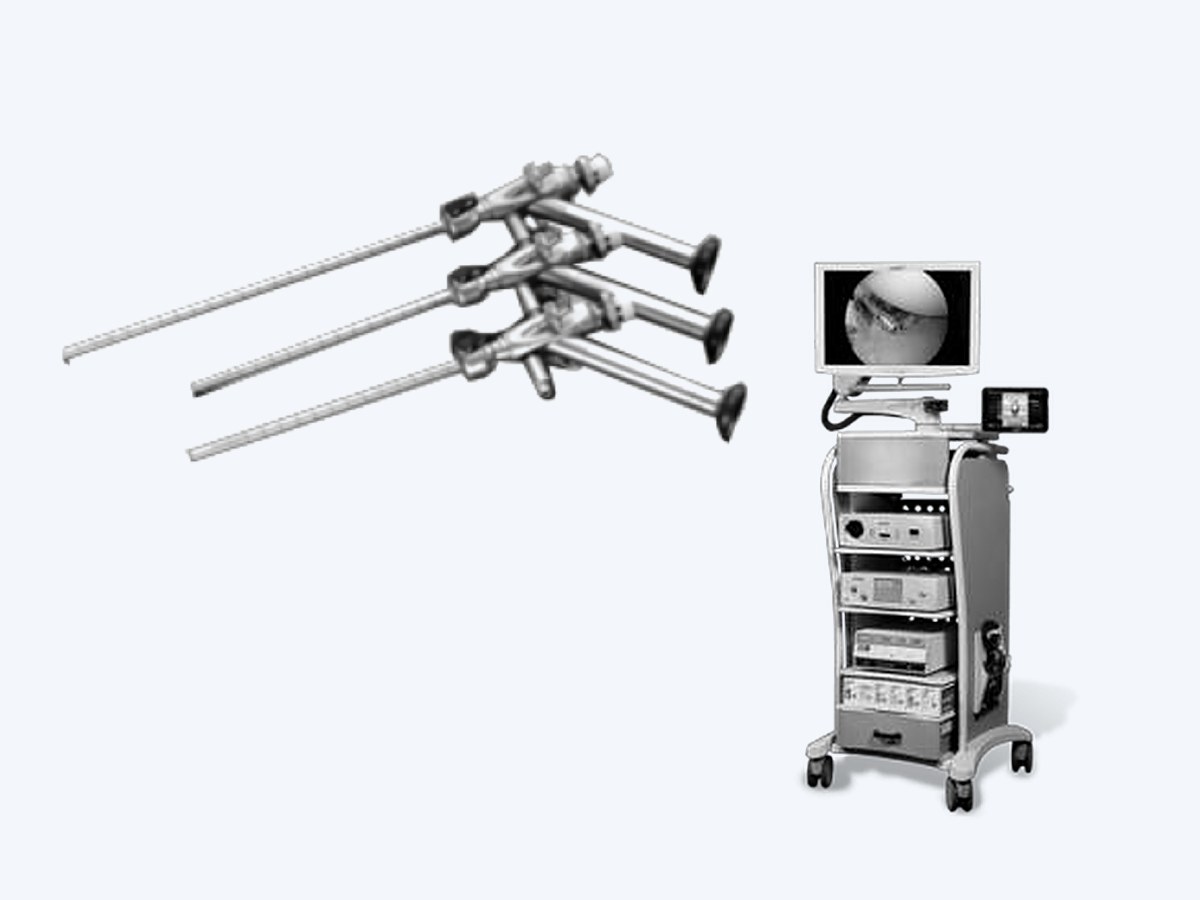 A set of conventional rigid endoscopes beside a processor tower — light source, camera unit and recorder stacked on a cart under a monitor